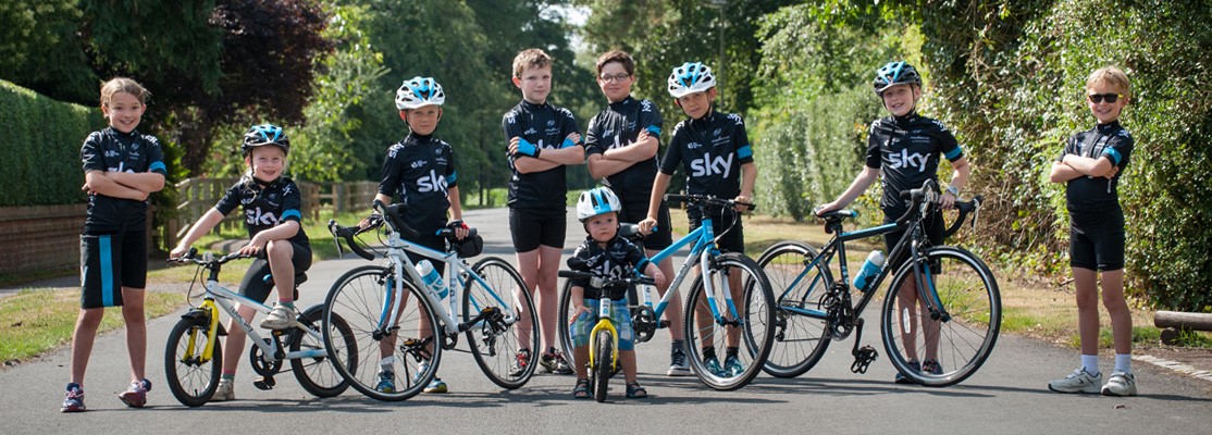 Children riding Frog Team Sky bikes with matching team kits