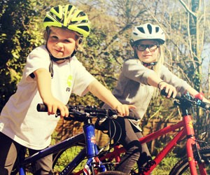 Two children riding Frog Kids Bikes in the sun